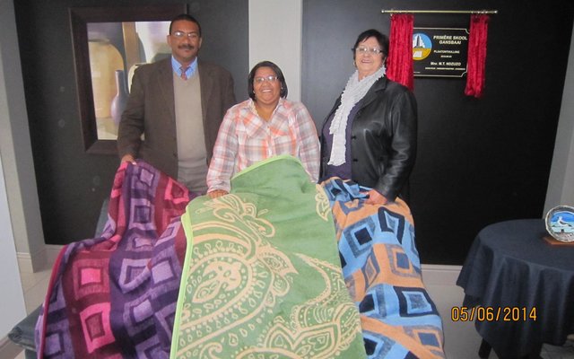 Vlnr is Tommy Volkwyn, Ellen Dunston en Ivy van Huyssteen tydens die oorhandiging van die warm komberse  